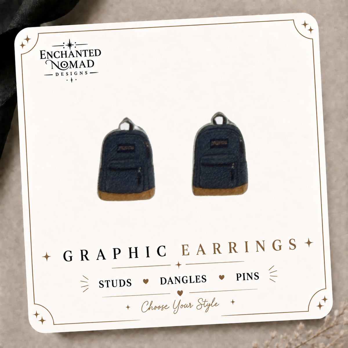 Backpack Stud Earrings on the tilted Enchanted Nomad Designs card