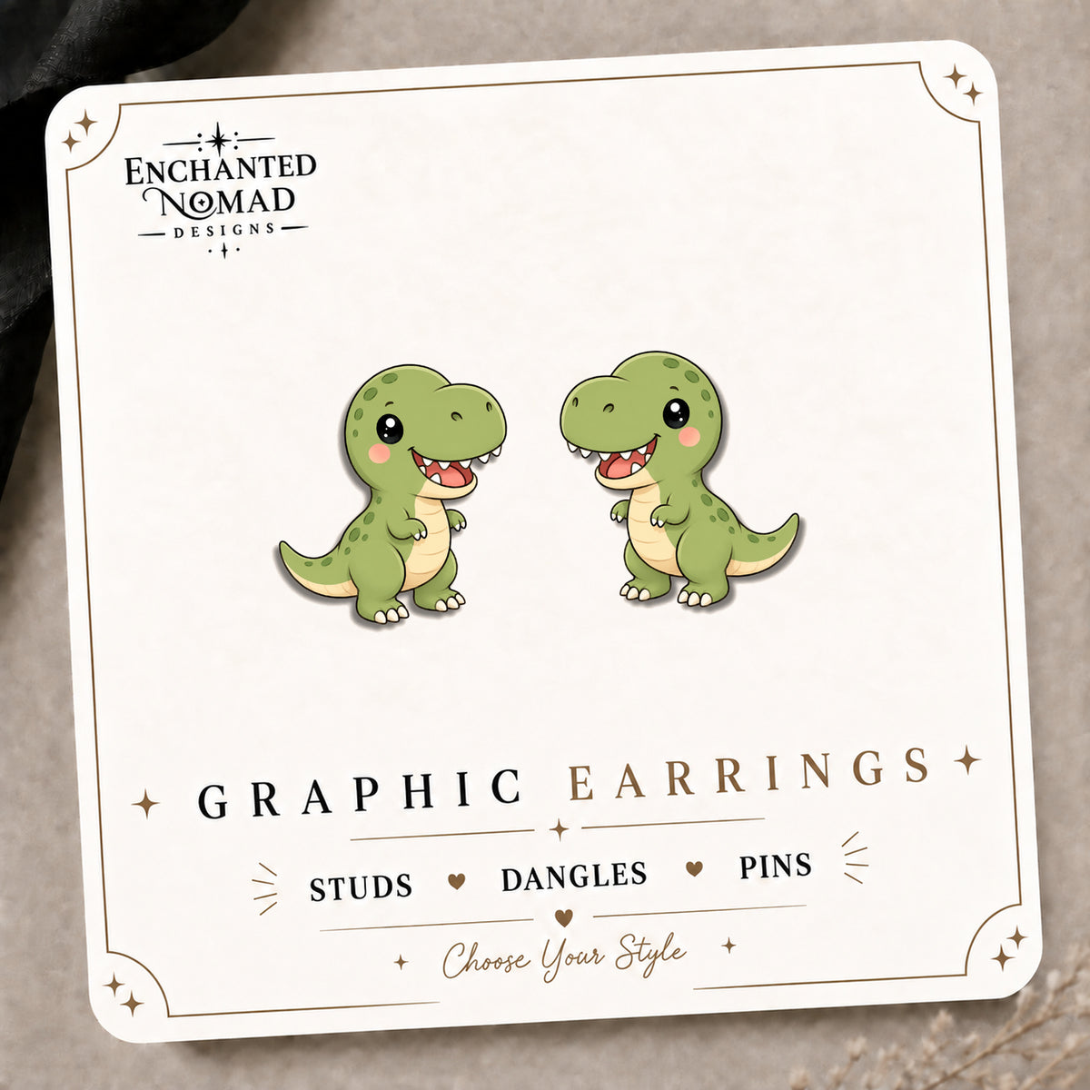 Cute T-Rex Stud Earrings on the tilted Enchanted Nomad Designs card