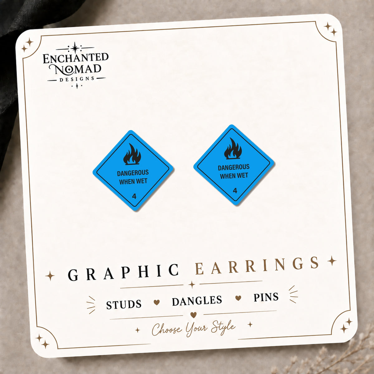 Dangerous When Wet Sign Earrings & Pins on the tilted Enchanted Nomad Designs card