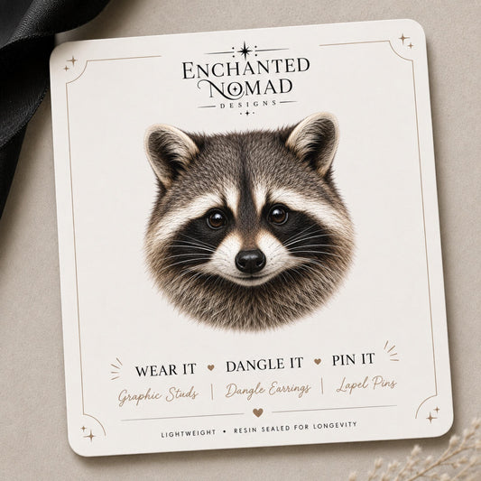 Raccoon Earrings & Pins on a branded display card