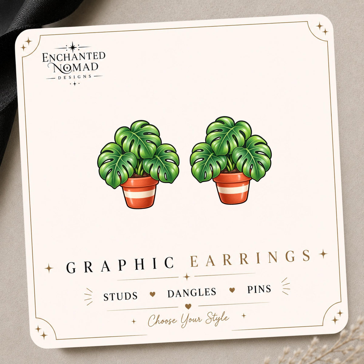 Monstera Plant graphic earrings and pins on a display card