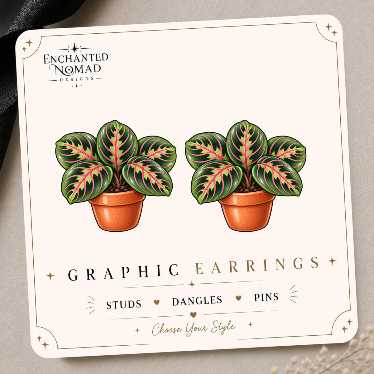 Prayer Plant graphic earrings and pins on a display card