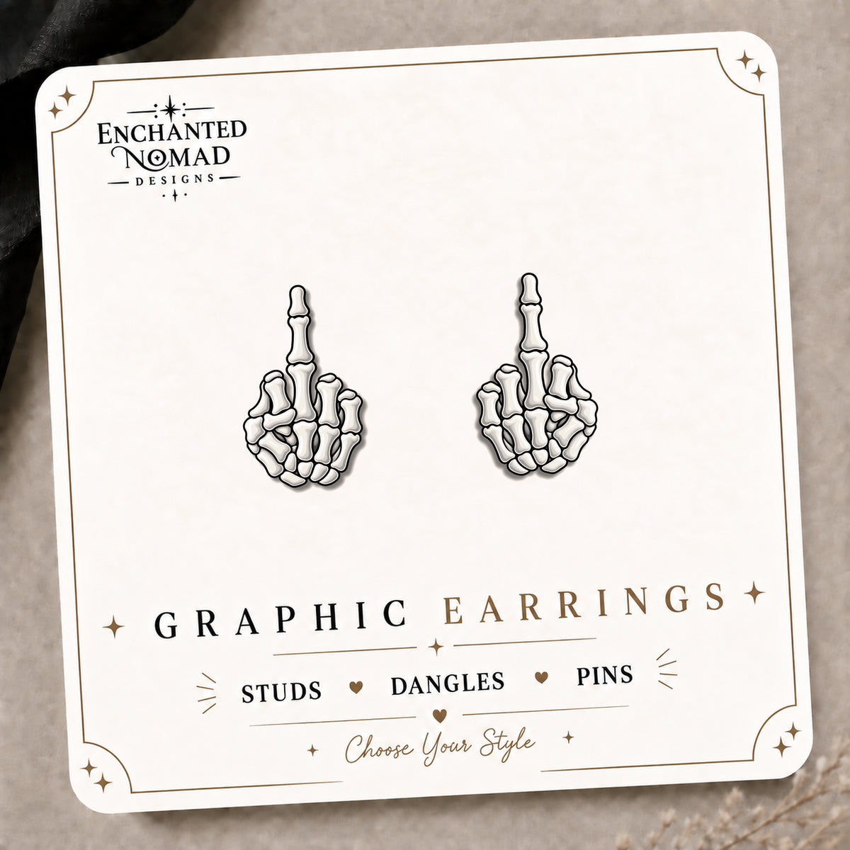 Skeleton Middle Finger Stud Earrings on the tilted Enchanted Nomad Designs card
