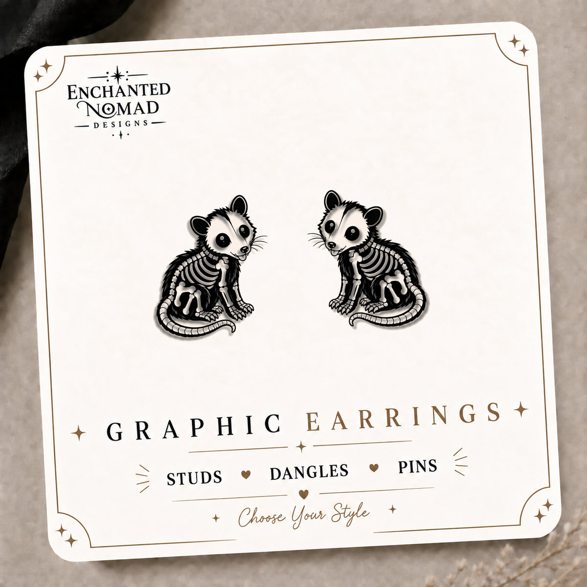 Skeleton Opossum Stud Earrings on the tilted Enchanted Nomad Designs card