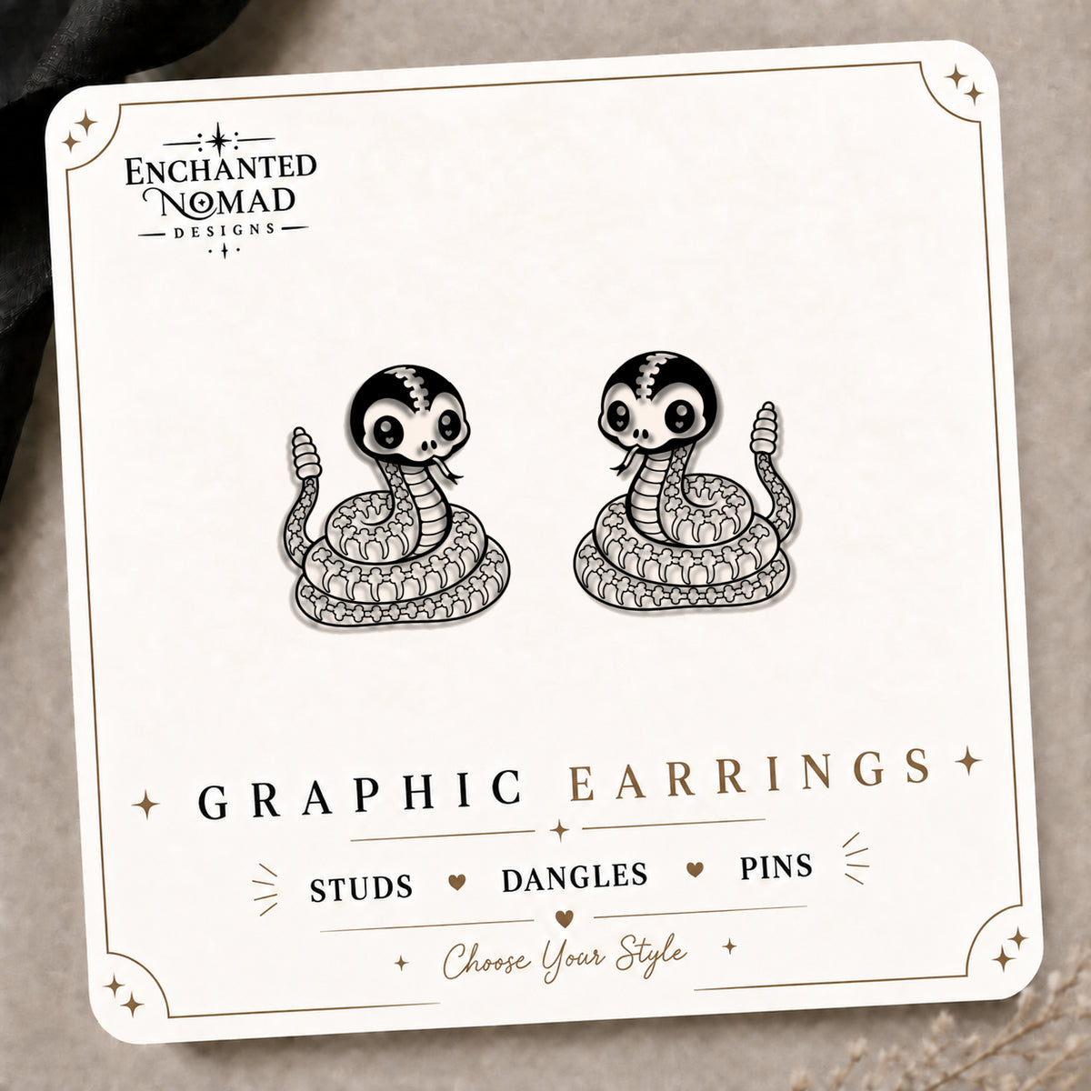 Skeleton Rattlesnake Stud Earrings on the tilted Enchanted Nomad Designs card