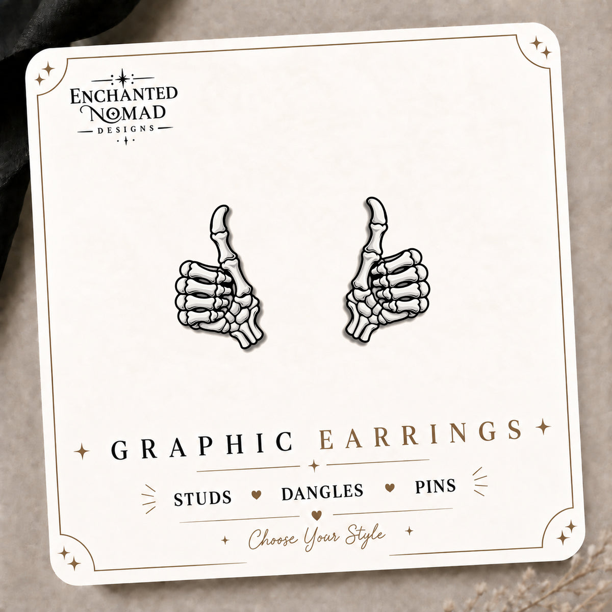 Skeleton Thumbs Up Stud Earrings on the tilted Enchanted Nomad Designs card